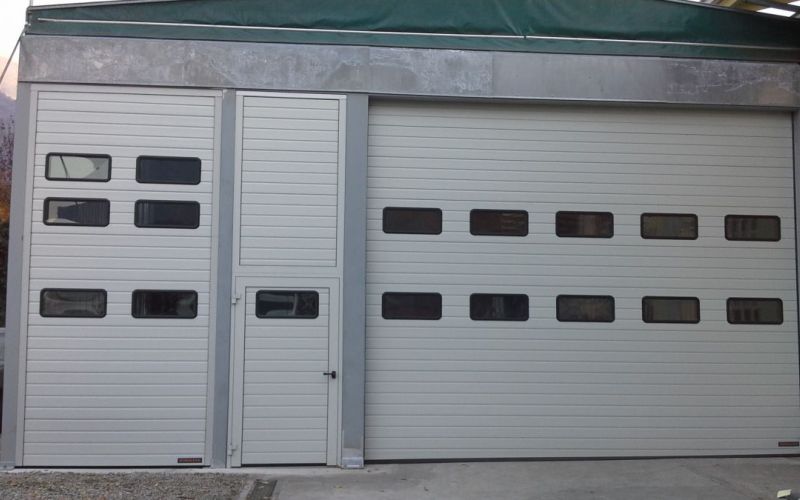 Chiusura industriale costituita da Portone , porta pedonale laterale e tamponamento con elementi fissi